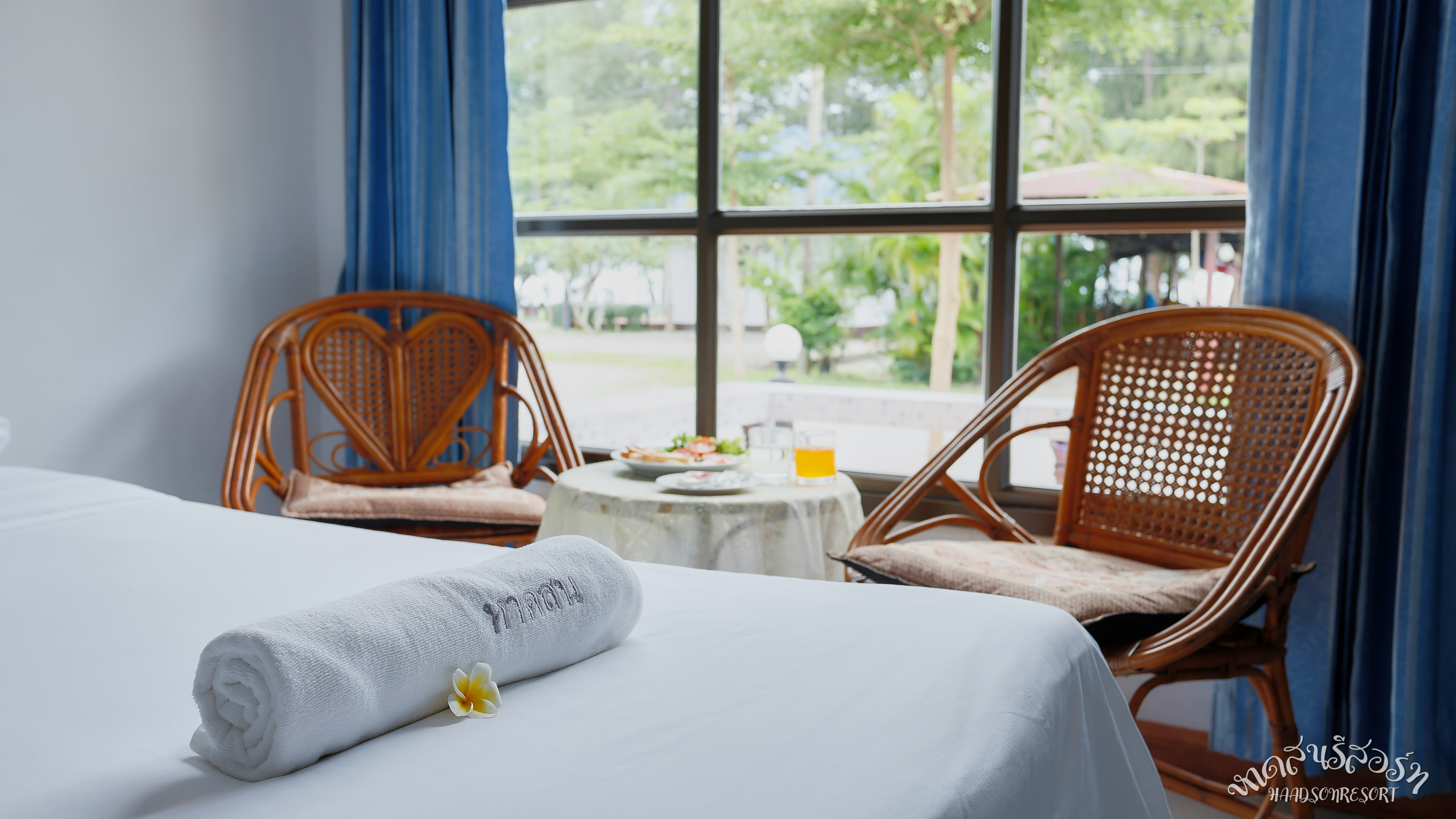 Standard Room มุมเตียง เก้าอี้หวาย บรรยากาศผ่อนคลาย